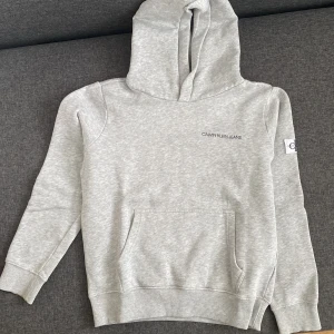 Calvin Klein Hoodie - Helt ny!!💗En sååå fin och basic grå hoodie ifrån Calvin Klein. Tyvärr är den förliten för mig. Storlek 12 år, passar XS 🫶🏼Obs lappen finns ej kvar
