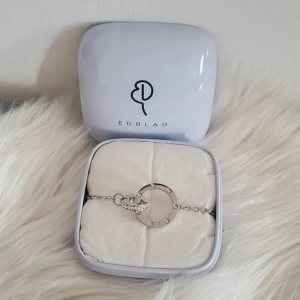  armband från Edblad  - Säljer ett stilrent armband från Edblad i silverfärg med två sammankopplade cirklar, 