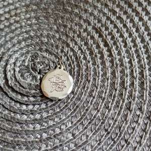 Runt tennhalsband med rosgravyr - Unikt runt halsband i tenn med en vacker graverad ros på framsidan. Märkt 'JLL TENN HANDARBETE' på baksidan. Perfekt accessoar för dig som gillar handgjorda smycken med klassisk känsla.