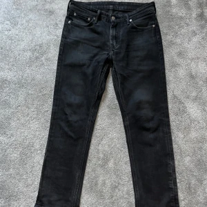 Svarta slim fit jeans från Levi's 511 - Säljer ett par svarta Levi's 511 jeans med klassisk femficksdesign och raka ben. Jeansen har slim passform och är tillverkade i ett mjukt denimtyg med dragkedja och knapp framtill. Perfekta för en stilren look.