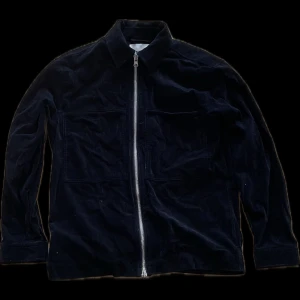 Svart manchesterjacka med dragkedja från NN.07 - Säljer en svart manchesterjacka från NN.07 i storlek S. Jackan har en rak passform, klassisk krage och hel dragkedja framtill. Perfekt för dig som gillar stilrena och tidlösa plagg med lite struktur. Dm för mer info