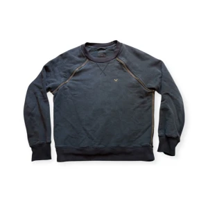 True Religion Sweater - True Religion Zipper Sweater. En riktigt unik sweater med dragkedjor, de funkar tyvärr inte då det bara är design. Längd: 65cm, Bredd: 53cm. Storlek M men passar även S. Kom DM vid fler frågor🙏