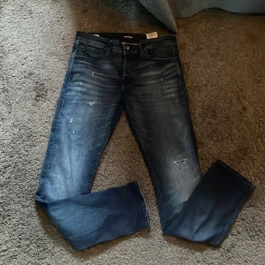 Jack and jones jeans - Säljer ett par mörkblå jack and jones byxor med sköna slitningar i storlek 32/32 // skriv vid mer funderingar 🙌🍺
