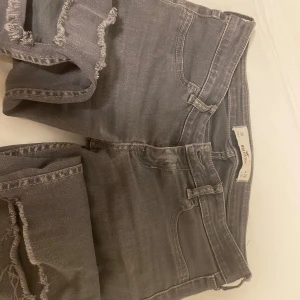 Grå jeansshorts från Hollister - Säljer ett par gråa super lowwaist jeans från Hollister med jeanshål på. 