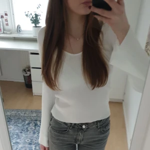 Vit ribbad långärmad topp  - Säljer en vit ribbad topp från Aware(vero moda) i storlek S. Toppen har lång ärm, v-ringad hals och är figurnära i modellen. Materialet är stretchigt och mjukt, vilket gör den superbekväm. Använd 2-4 gånger max.