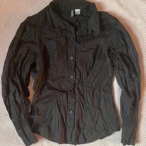 Svart skjorta - Snygg svart skjorta med ballong ärmar. Är i mycket bra skick och är i storlek 36!