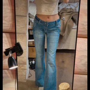 Blå bootcut jeans med låg midja - Säljer ett par ljusblå bootcut jeans med låg midja. De är avklippta i benen och jag har sytt in resor I midjan ( inte tajt)