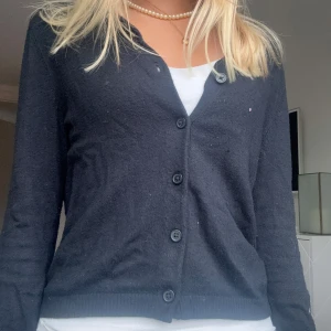 Svart kofta med knappar - Säljer en svart kofta med långa ärmar och knäppning fram till💘 stilren design som passar till allt! Koftan är i superskönt och mjukt material!❣️ Perfekt att slänga över en topp eller t-shirt. 