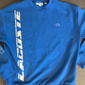 Blå loose fit sweatshirt från Lacoste - Säljer en blå sweatshirt från Lacoste, som en ny , Perfekt för en sportig och avslappnad stil.
