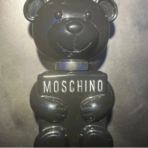 Moschino Toy Boy EDP - Moschino Toy Boy EDP 30ml – Ca 20+ml kvar ‼️ 	•	Säsong: Höst, vinter, vår 	•	Passar för: Kväll, dejt, fest 	•	Doft: Fruktig och kryddig toppnot, blommiga och träiga hjärtnoter, avslutas med rökig musk. 	•	Beskrivning: En unik, maskulin doft med sötma och djup, perfekt för kalla månader och speciella kvällar.