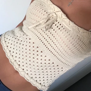 Virkad cremefärgad linnetopp  - Supersöt virkad linnetopp i cremevitt med smala axelband och knytning framtill. Toppen har hålmönster och vågig kant nertill. Perfekt till sommaren och ger en chill boho-vibe.  Toppen är använd fåtal gånger med inga tecken på användning 🤍                         kontakta vid frågor eller mer bilder 🤍 