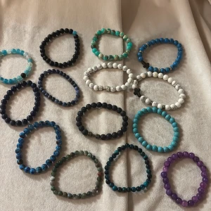 Färgglada pärlarmband i olika stenar - Säljer ett gäng elastiska armband med runda pärlor i olika färger och stenar. Här finns blå, turkosa, svarta, vita, gröna och lila toner, vissa med marmorerad effekt och detaljer som små metallpärlor och kors. Perfekt för dig som vill mixa och matcha din stil. Kontokta för köp av specifika, kan köpa hur många ni vill 49kr/st