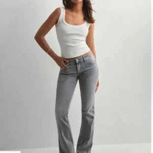Grå bootcut jeans med normal passform - Snygga grå jeans från Nelly med bootcut-snitt och klassisk femficksdesign. Jeansen storlek M /32 och är tillverkade i mjukt denimtyg med lätt tvättad look. Perfekta för dig som gillar en stilren och avslappnad vibe. 