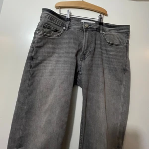 Grå jeans från Smog/Denim, 30/30 - Snygga grå jeans från Smog/Denim i klassisk femficksmodell. Jeansen har en rak passform och är tillverkade i mjukt denimtyg. Färgen är tvättad grå med lätt slitning för en cool look. Perfekta för dig som gillar stilrena och enkla jeans. Knappt använd