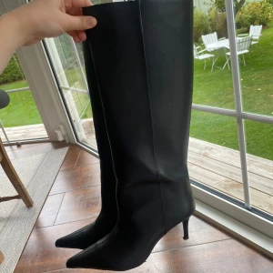 Svarta stövlar med klack från H&M - Snygga svarta stövlar från H&M med spetsig tå och smal klack. Stövlarna är höga och har en stilren design i syntetmaterial, perfekta för att lyfta din höstlook. Passar dig som gillar trendiga och eleganta boots. Storlek 37, använda en gång men jag beställde två storlekar och tyckte denna va för liten för mig, skicka meddelande för fler bilder nästan slutsålda på hemsidan☺️