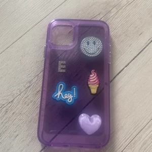 Mobilskal -  Lila mobilskal med block glass lila hjärta hej blå text :-) silvrig pärl smiley och ett silvrigt pärl E 