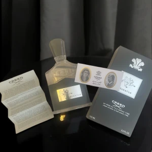 Creed Aventus 100ml Eau de Parfum - Lyxig parfym från Creed, Aventus, i en elegant genomskinlig glasflaska med svart och silverdetaljer. Flaskan rymmer 100 ml och har en stilren svart kork. Kommer med originalförpackning och informationsblad. Tillverkad i Frankrike.