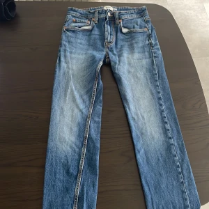 Blå slim jeans från 157, W30 L32 - Snygga blå slim jeans från 157 i klassisk tvätt med slitningar och kontrastsömmar. Modellen är smal och har fem fickor samt dragkedjegylf. Perfekta för dig som gillar en modern och enkel look.