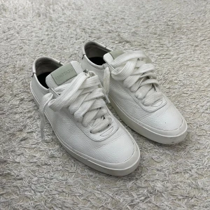 Vita sneakers från Limitato i skinn - Stilrena vita sneakers från Limitato i mjukt skinn med rund tå och platt sula. Klassisk design med breda vita snören och diskret logga på plösen. Perfekta för en clean och modern look.