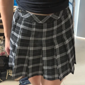 Rutig kjol från H&M - Svart kjol med vitt & grått rutigt mönster. Storlek är i S & den är ej använd. Hade själv tänkt ha den till en halloween fest som en american school girl som inte blev av, men definitivt perfekt för det.