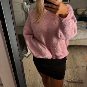 Rosa stickad tröja - Mysig rosa stickad tröja med loose fit och långa ärmar. Tröjan har en enkel design med ribbade muddar vid ärmslut och nederkant. Perfekt för dig som gillar en avslappnad och trendig stil.