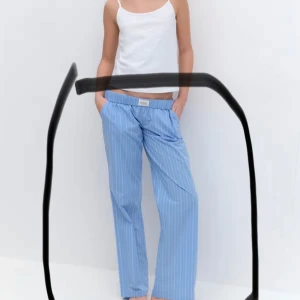 Blå randiga byxor med resårmidja - Säljer ett par chill blåa byxor med vita ränder och resår i midjan. De har en loose fit och raka ben, perfekta för en avslappnad look. Byxorna har fickor på sidorna och är gjorda i mjukt bomullstyg.low waist köpte för 329 säljer för 50kr 