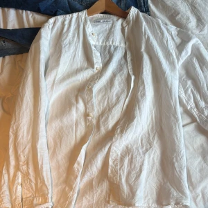 Vit linneskjorta från Zara, M - Säljer en stilren vit linneskjorta från Zara i storlek M. Skjortan har en avslappnad passform, knappar framtill och lång ärm. Perfekt för varmare dagar tack vare det tunna och svala linnetyget. Enkel och fräsch design utan krage.