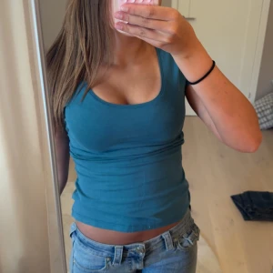Turkos topp  - Enkel och snygg turkos topp från 365 med rundad halsringning och korta ärmar. Modellen är figurnära och passar perfekt till jeans eller kjol. Super söt färg som man kan styla till de mesta! 