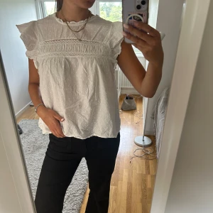 Vit blus - Supersöt vit blus med volangärmar och broderade spetsdetaljer över bröstet. Den är ifrån Vero Moda i storlek L. Hör av dig vid frågor🤍🤍