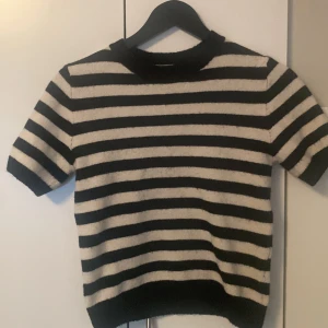 Randig stickad tröja från H&M XS - Säljer en svart och vit randig stickad tröja från H&M i storlek XS. Tröjan har korta ärmar och en klassisk rund halsringning. Perfekt för dig som gillar en enkel men ändå trendig look med lite retrovibbar.💞