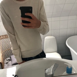 J.Lindeberg 100% merinoull stickad tröja - Tja! Säljer en as fet beige merino tröja från JLindeberg. As najs passform. Hör av dig vid funderingar!