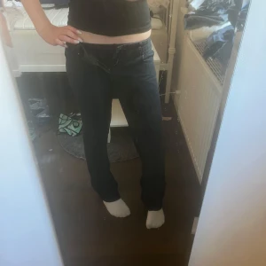 Svarta utsvängda jeans - Säljer ett par svarta jeans med rak passform och klassisk femficksdesign. Jeansen har låg midja och är tillverkade i ett mjukt denimtyg som sitter skönt hela dagen. Perfekta till sneakers eller boots. 💞