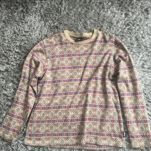 Mönstrad långärmad tröja från Stüssy - Säljer en beige långärmad tröja från Stüssy. Bra skick, strl M.