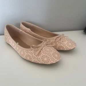 Beige spetsballerinor från Anna Field - Söta ballerinaskor i beige från Anna Field med blommig spets och liten rosett framtill. Dom är aldrig använda. Priset går att diskutera!