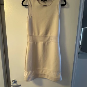 Beige ärmlös klänning från Bik Bok - Snygg beige kortklänning från Bik Bok i ärmlös modell. Använt en gång på en fest annars är den inte använts. Det är inte heller min stil 