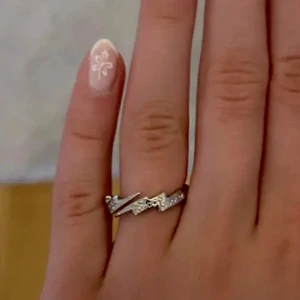 Snygg silverring med kristalliknande grejer - Säljer en stilren silverring med små gnistrande stenar i ett blixt mönster. Aldrig använd. Köpt på IrisJewerly och är justerbar. Fråga om du har funderingar ❤️