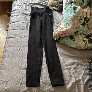 Svarta ribbade leggings Aim'n - Säljer ett par svarta ribbade leggings från Aim'n med hög midja och tight passform. De är tillverkade i ett stretchigt material som sitter skönt och följer kroppen. Perfekta för dig som gillar stilrena och bekväma byxor med sportig känsla.