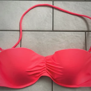 Rosa bikini från Victoria's Secret - Snygg rosa bikiniöverdel från Victoria's Secret med avtagbara axelband. Det är en söt modell med lätt rynk framtill och justerbart spänne i ryggen. Storlek 36B och endast provad.