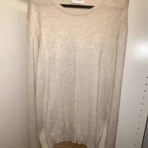 Beige stickad tröja från Lindbergh - Säljer en stilren beige stickad tröja från Lindbergh White. Tröjan har rund halsringning, långa ärmar och en klassisk passform. Perfekt för lager-på-lager och enkel att matcha med jeans eller chinos. Den är i storlek S och passar som S. Passar bra som en simpel tröja över sin T-shirt. Skriv till mig om du har några funderingar! 😆