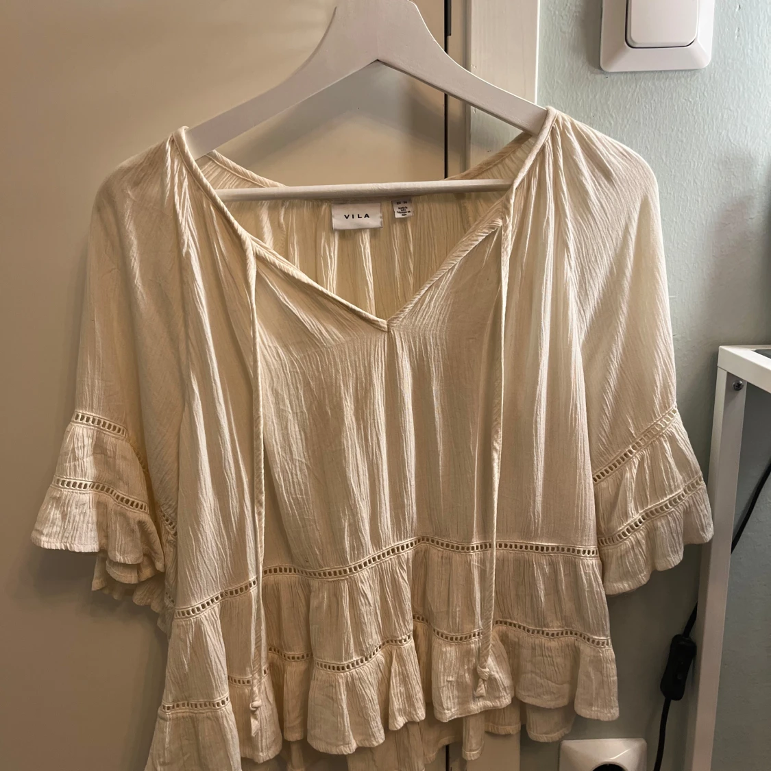 Krämvit blus med volanger från Vila