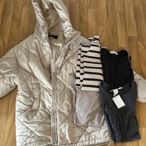 Inspoco box strl S - Säljer en beige pufferjacka från New Yorker med quiltat mönster och stor huva. Jackan har dragkedja framtill och två fickor på sidorna. Perfekt för kyliga dagar och riktigt skön att bära. Passformen är normal och jackan är lätt att matcha med olika outfits.Jackan saknar bara en ”drag” knapp, men de kan man lätt fixa. Obs kolla bild   -En tröja/blus med prislappen på  -En tröja  -En klänning - En lite längre tunika  Allt strl S  