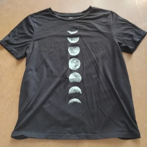 Månfas Tshirt - Svart t-shirt med tryck av månfas. Storlek S från Shein, passar även M. Tyget är en bomullsblandning, känns som bomull. Använd och tvättad några gånger så fint skick, trycket är helt intakt.