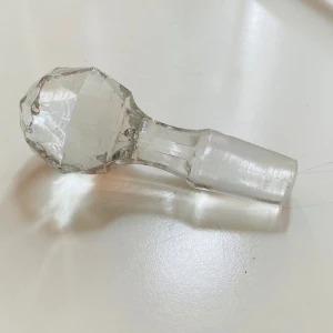 Glaskork - Bilderna visar en glaskristallpropp, troligen till en karaff eller flaska. Den är slipad med fasetterad topp och mäter cirka 8 cm. Inga skador