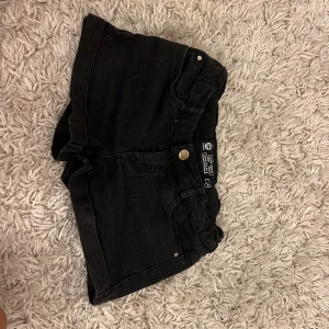 Svarta jeansshorts från Your Denim - Svarta jeansshorts från Your Denim med klassisk femficksdesign, gylf med knapp och bälteshällor. Modellen är kort och har en rak passform. Perfekta för varma dagar när du vill ha en enkel och stilren look.