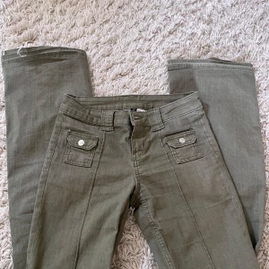 Olivgröna byxor från H&M Divided - Säljer dessa gröna byxor fårn hm utan fickor där bak. Jeansen är i storlek 34. Jag har sprettat upp byxorna där nere så de är längre än vanligt men i bra skick💕