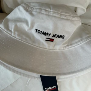 Vit bucket hat från Tommy Jeans - Vit bucket hat från Tommy Jeans som inte görs längre exakt i denna design. Helt oanvänd