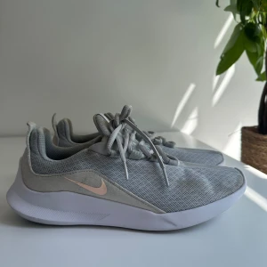 Grå Nike träningsskor - Hej! Säljer dessa dam Nike tränings skorna i storlek 39. Skorna sitter normalt i storleken och det finns inga defekter som hål eller upprivet tyg. Den enda deffekten är fläckarna som syns i bilderna (vet inte hur dessa kom), men annars har skorna mycket kvar att ge! Skickar skorna inom 24 timmar efter köp. 📦 