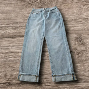 Ljusblå raka jeans från 157 - Ljusblå jeans med raka ben och uppvikta benslut från 157. Klassisk femficksmodell med hög midja och bälteshällor. Jeansen är i mjukt denimtyg och har en snygg vintagekänsla. Perfekta för en avslappnad och trendig look.