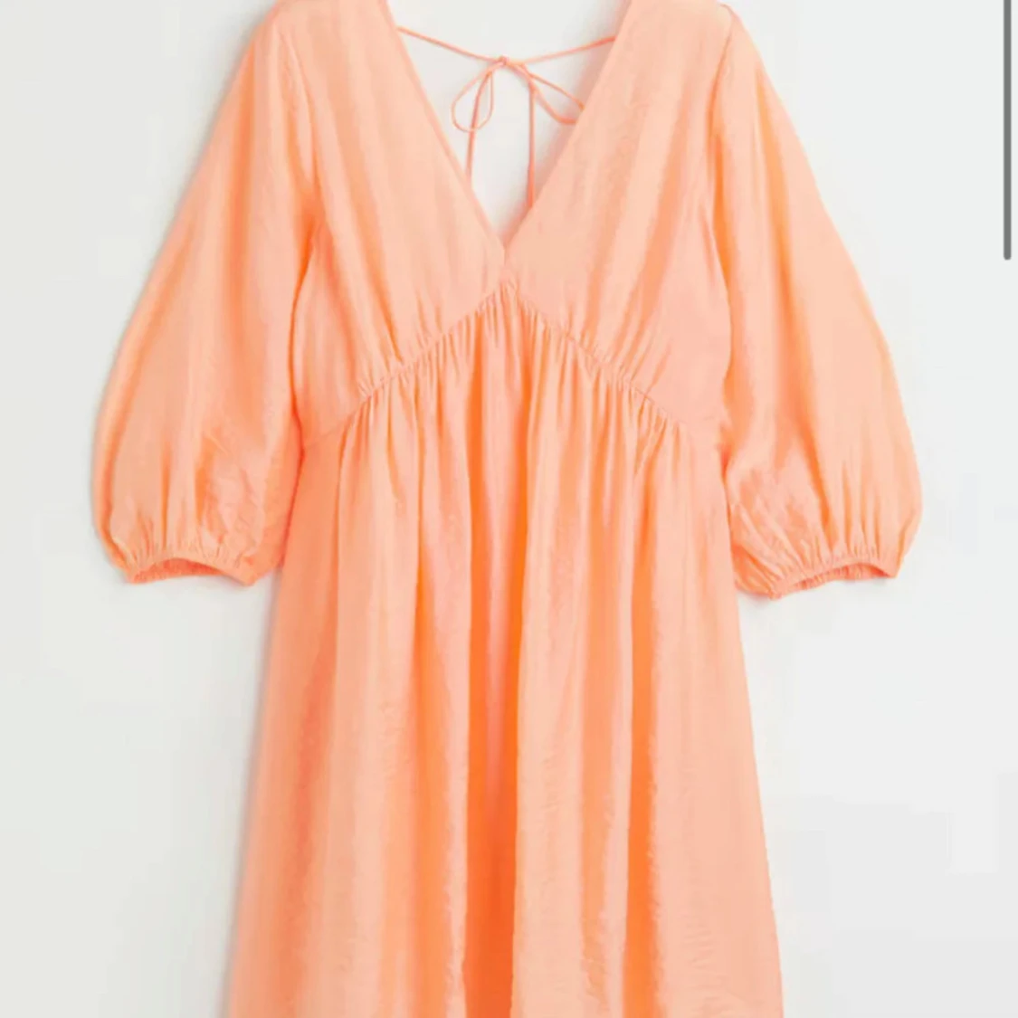 Persikofärgad kort klänning med v-ringning - 1