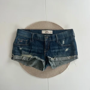 Lågmidjade jeansshorts Hollister  - Ett par Hollister jeansshorts i storlek W27 (S). Rakt över midjemått: 38cm. Längd: 18cm. Gren: 17cm. OBS! Jag skickar dem allra sista paketen den 13 juni, köp efter den 13 juni skickas som tidigast den 22 juni. D10